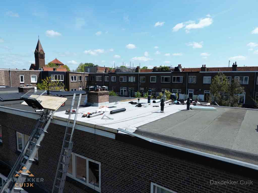 Dakdekkers aan het werk op plat dak in Cuijk