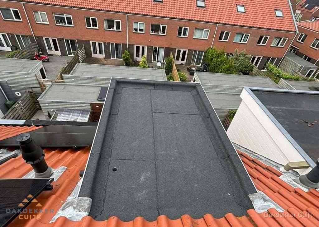 Plat dak met bitumen bedekking naast dakkapel in Cuijk