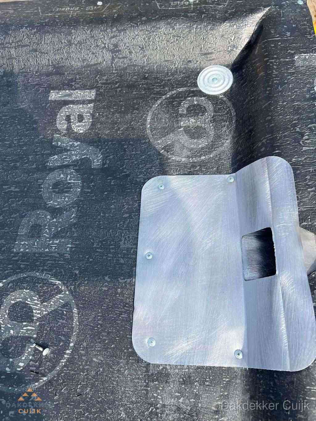 Dakdoorvoer met metalen afvoerplaat op bitumen dak in Cuijk