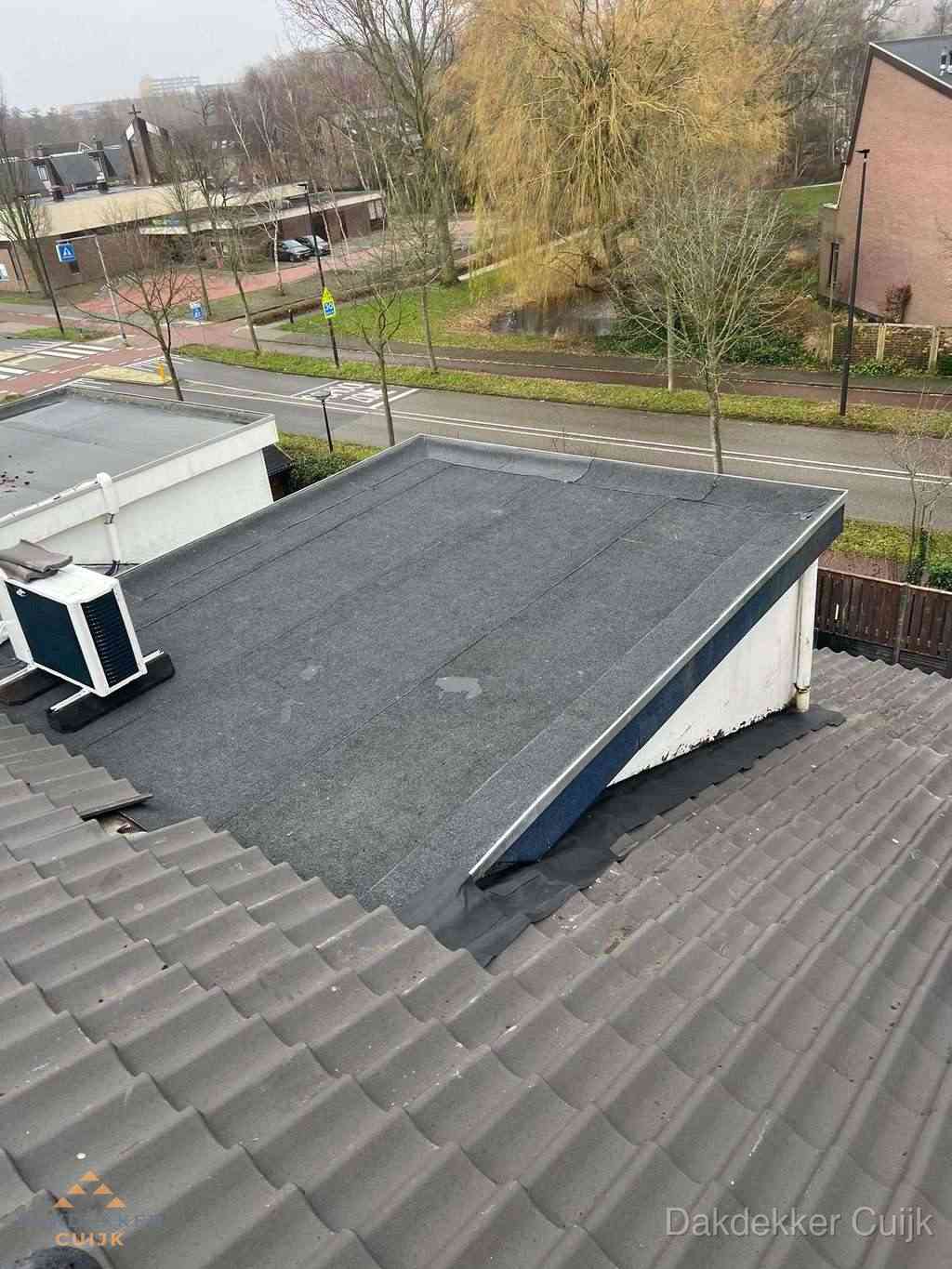 Plat dak met bitumen dakbedekking naast schuin pannendak in Cuijk