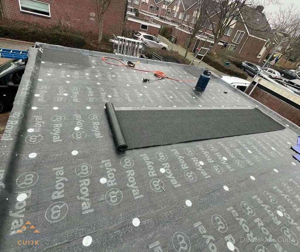 Dakdekker aan het werk met gasbrander op plat bitumen dak in Cuijk