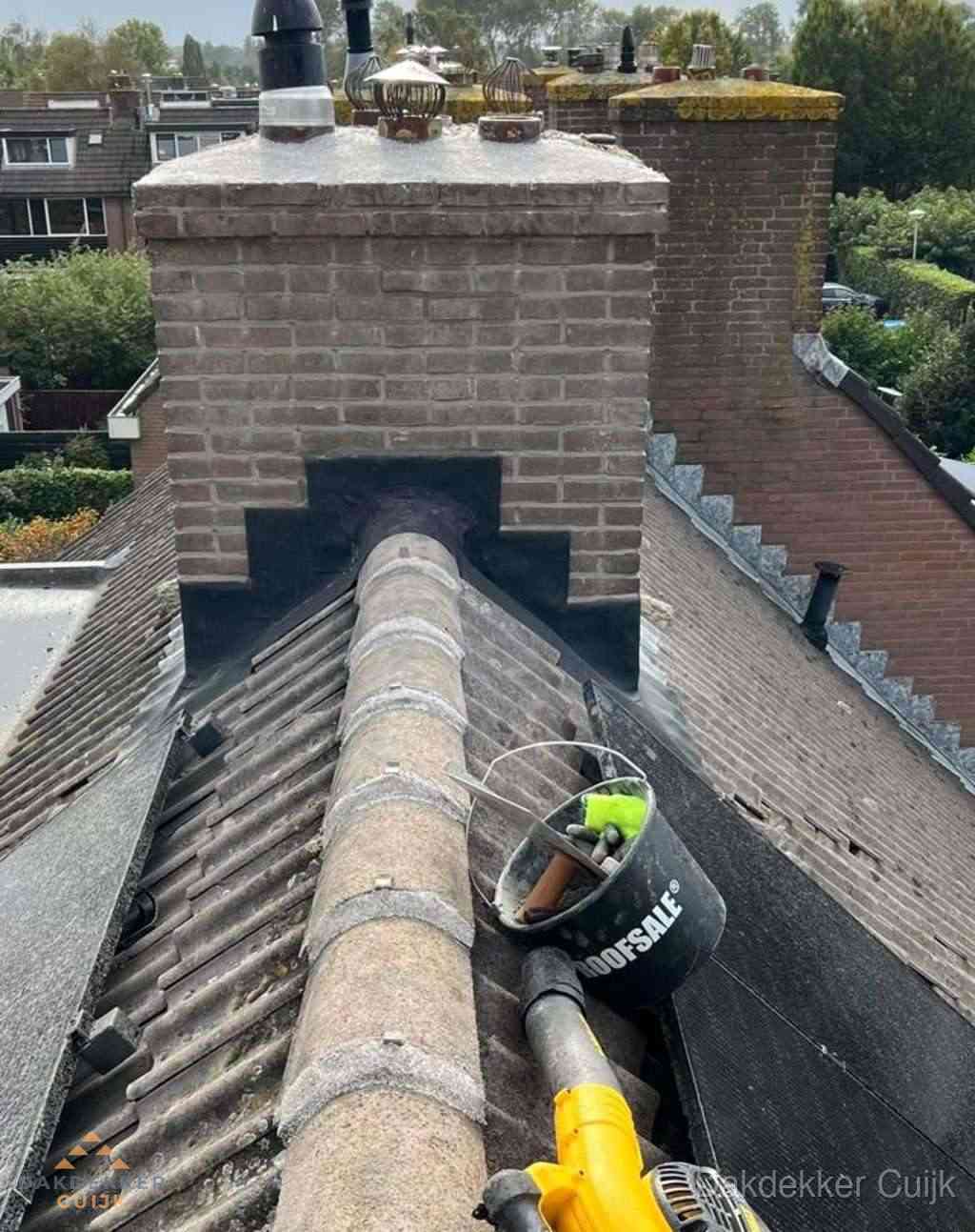 Dakdekker repareert bitumen dakleer bij dakdoorvoer in Cuijk